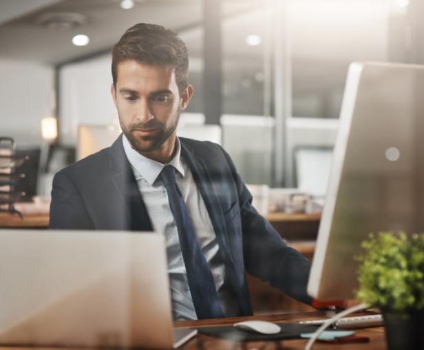A person in a suit and tie looking at a computer